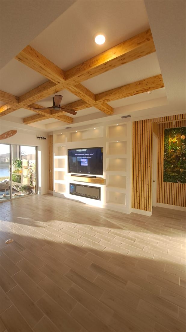 Living room with wood ceiling beams, slat accent wall and built-in media wall