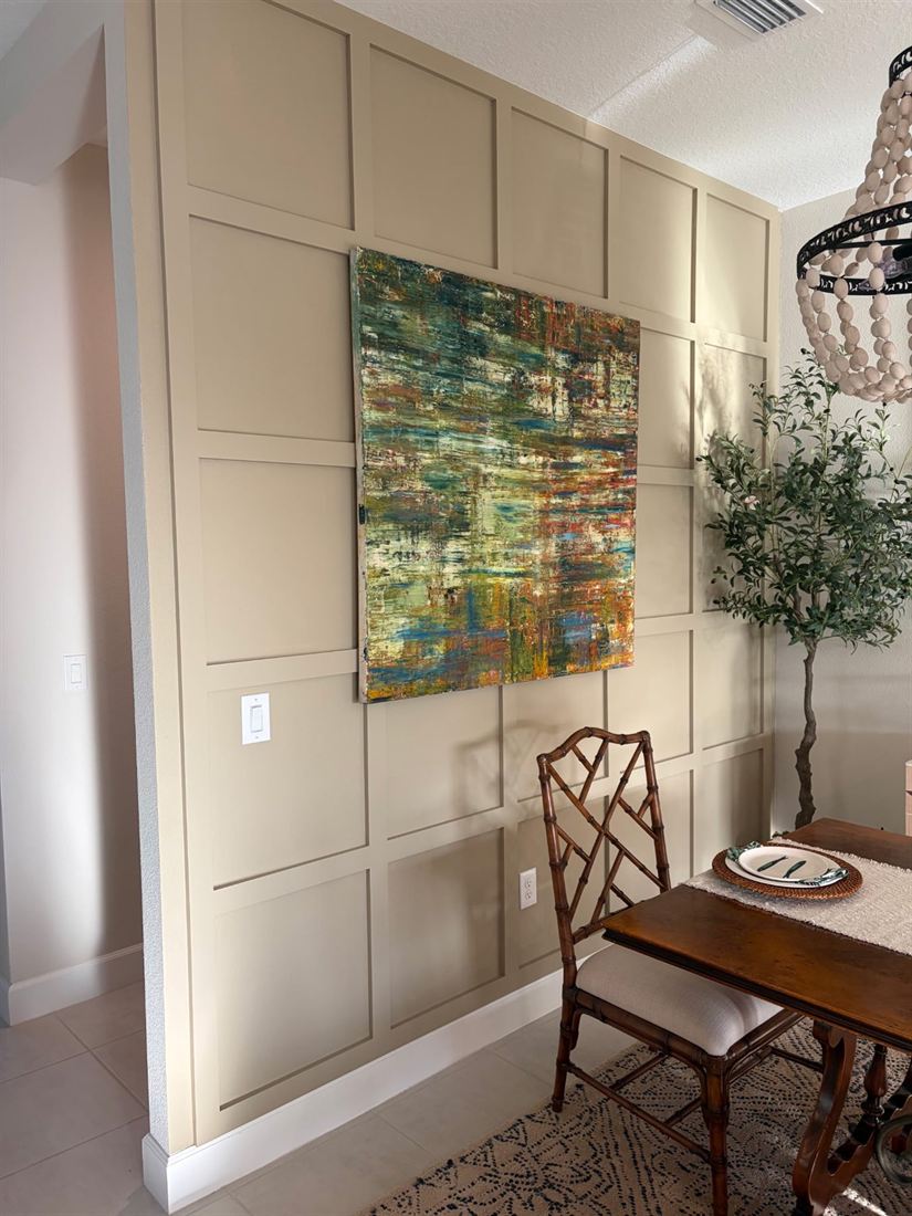 Warm neutral dining room accent wall finished in a custom square panel design