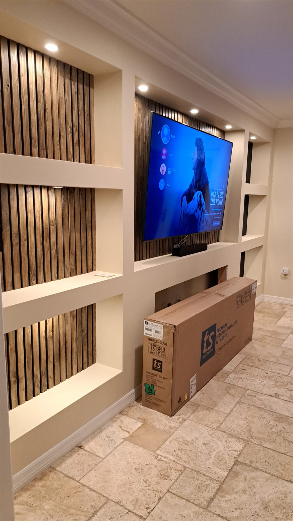 Built-in media wall with dark wood slat panels behind the television